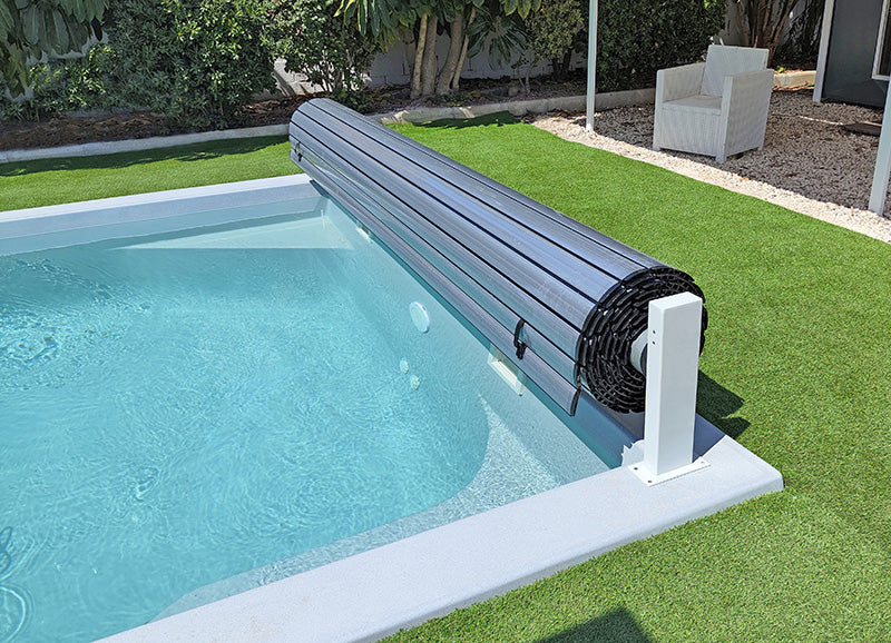 Terra Lite: roller enrollable cubo de piscina enrollable sobre borde de piscina, desplegado para cubrir el agua.