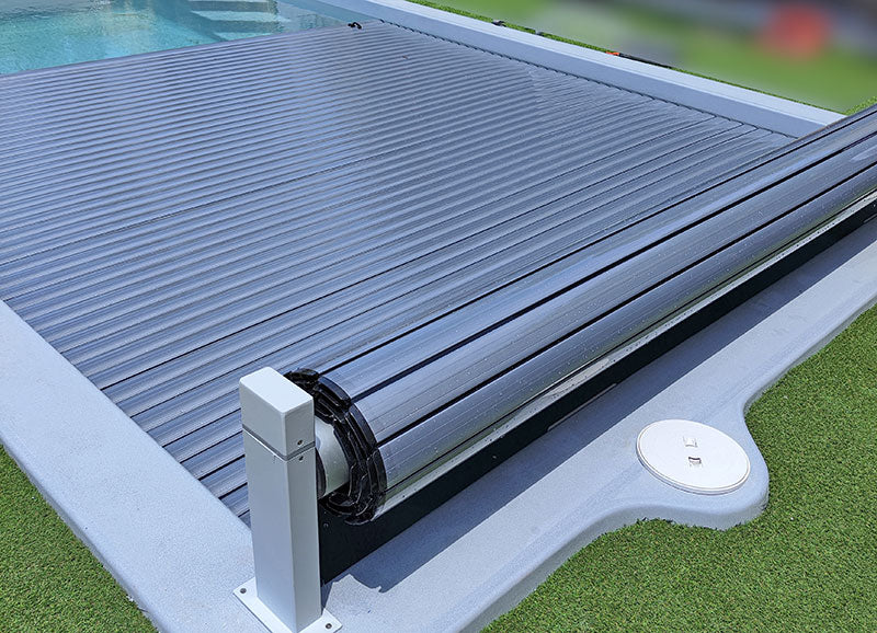 Tela solar enrollable Terra Lite instalada en piscina, cubre y protege la zona con láminas enrollables.